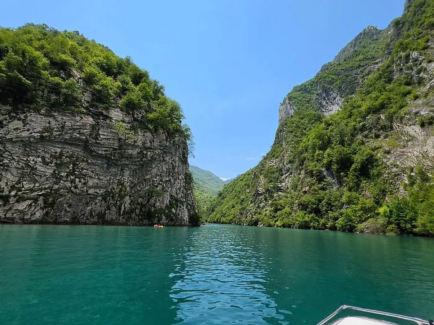 Passenger ferry crossing the narrow Komani Lake gorge in morning light